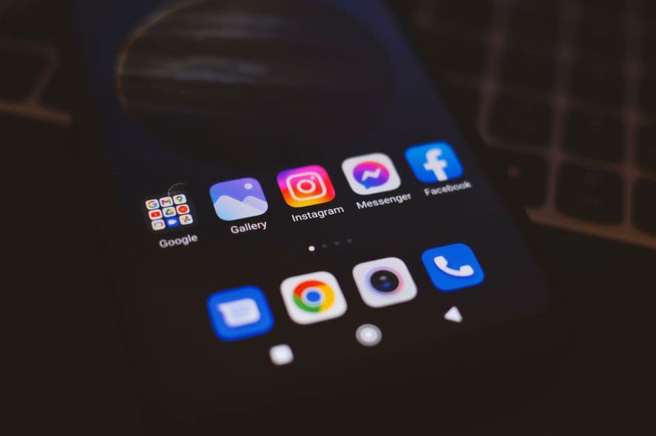Smartphone exibindo aplicativos populares em uma tela escura